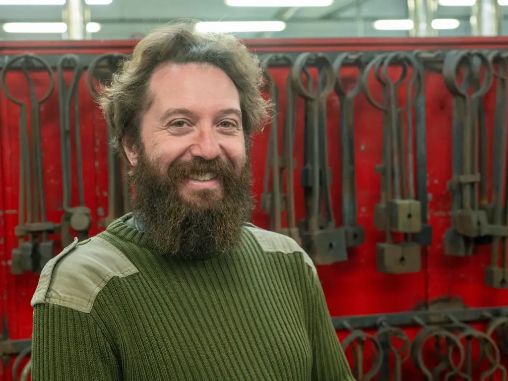 Rowan at the forge in a green jumper