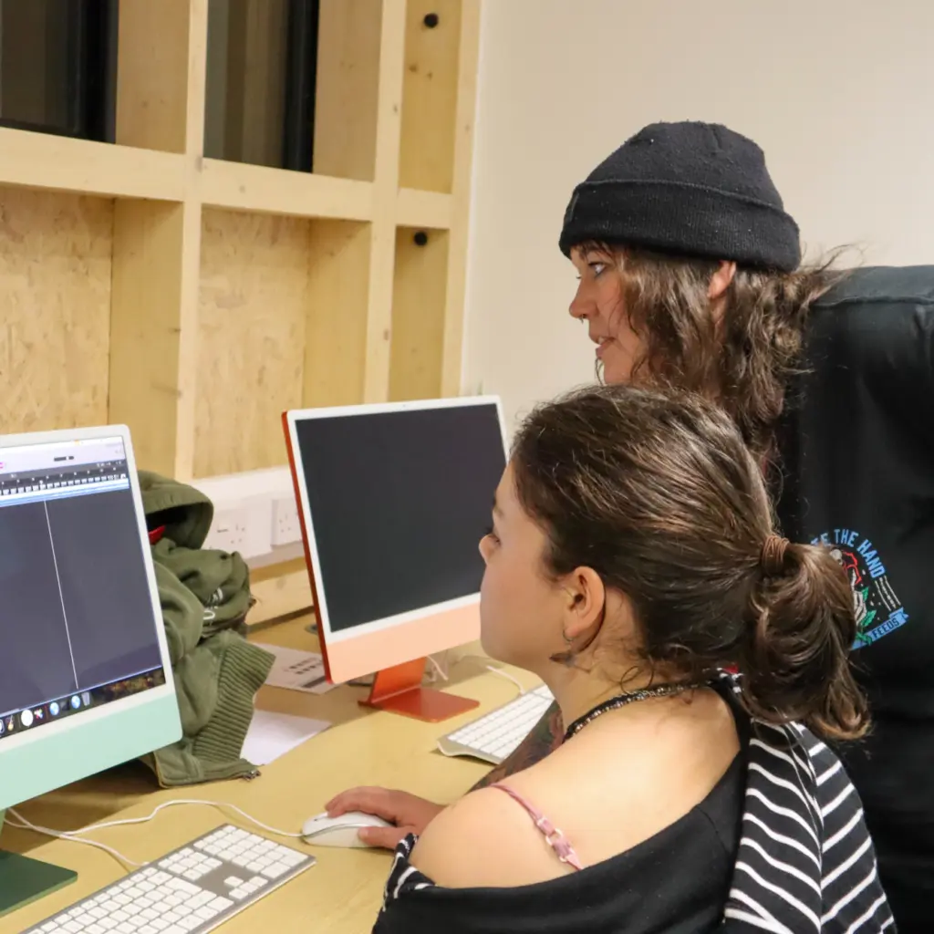 Zoe is helping demonstrate how to use a function on Logic Pro. The student watches what she is doing on the screen.