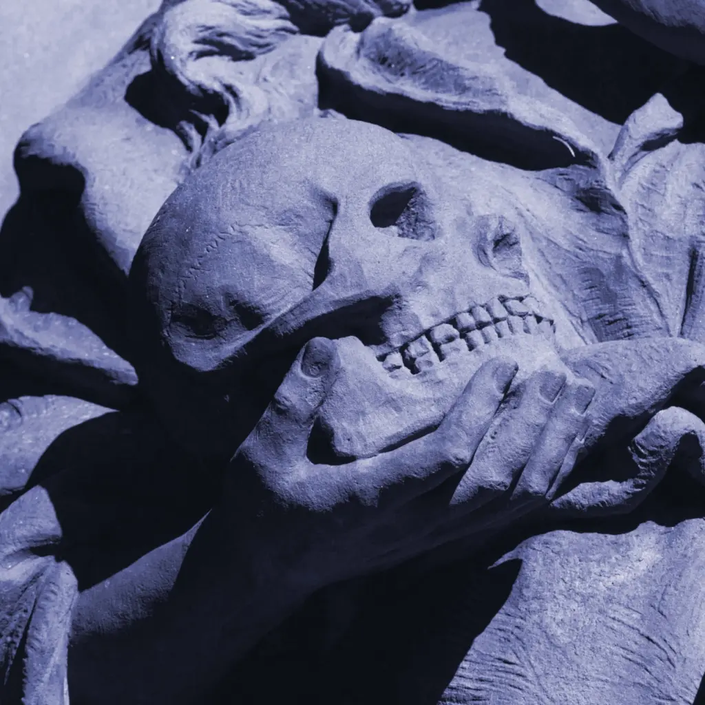 A tinted Black and White photo of a sculptural hand holding a skull.