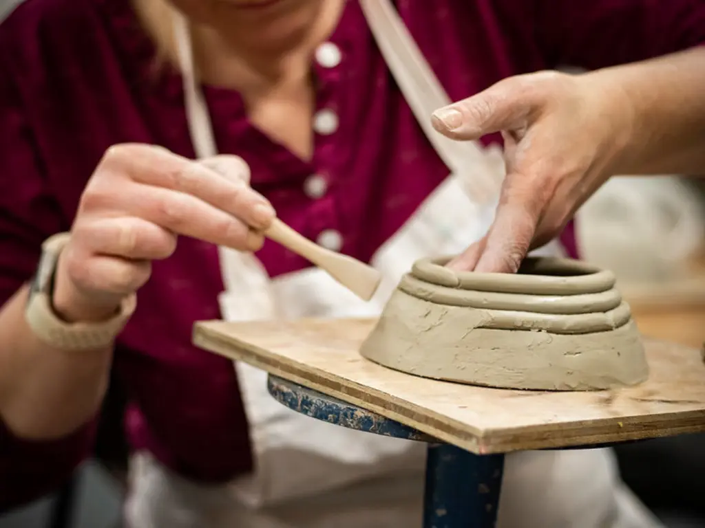 Someone coil-building a clay vessel